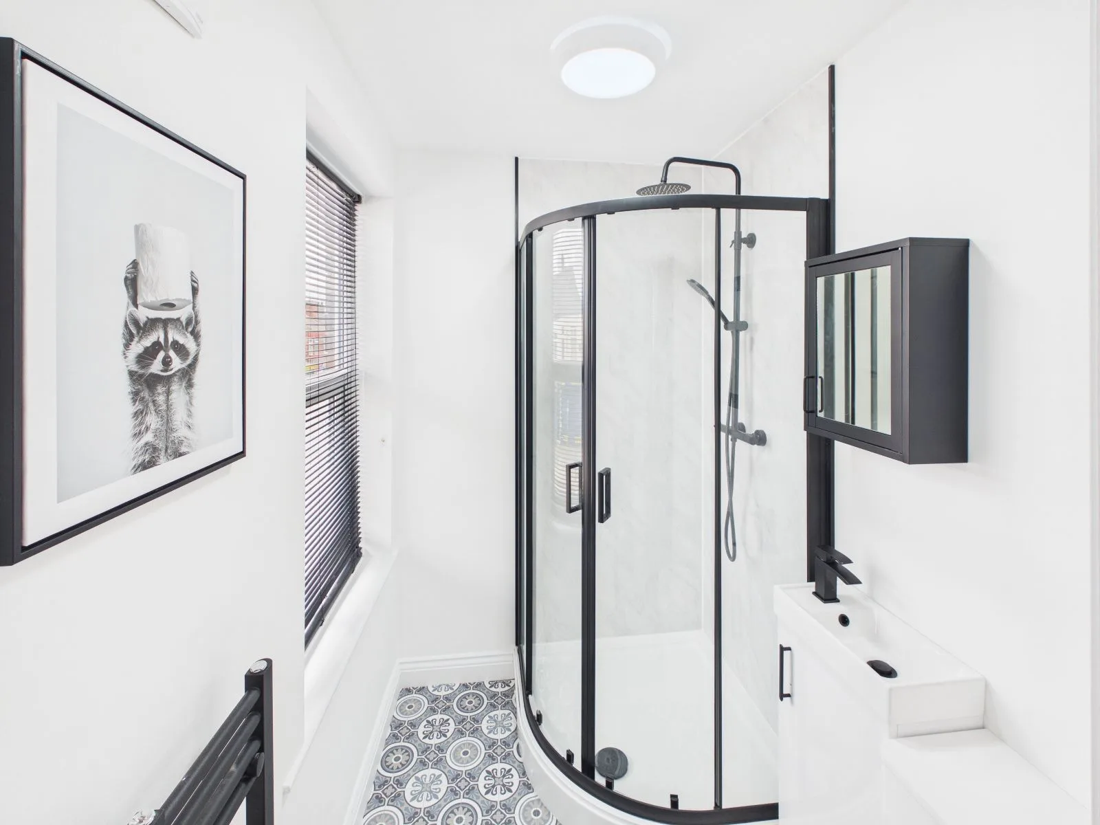 Shower room with a quadrant enclosure and patterned floor tiling at the completed Darlington HMO.